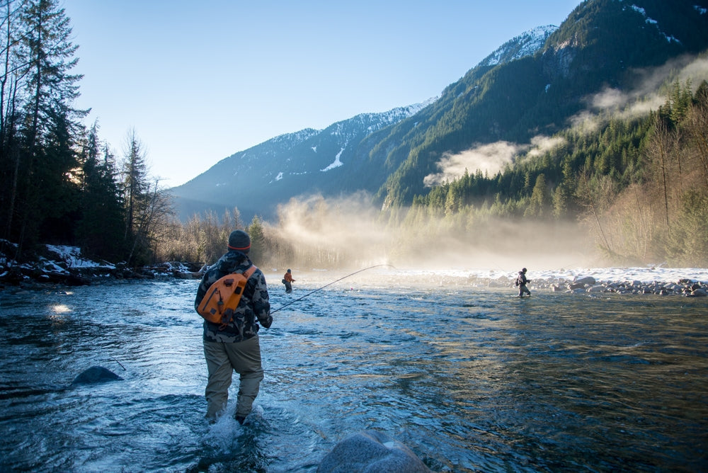 fly fisherman wearing essential fly fishing gear