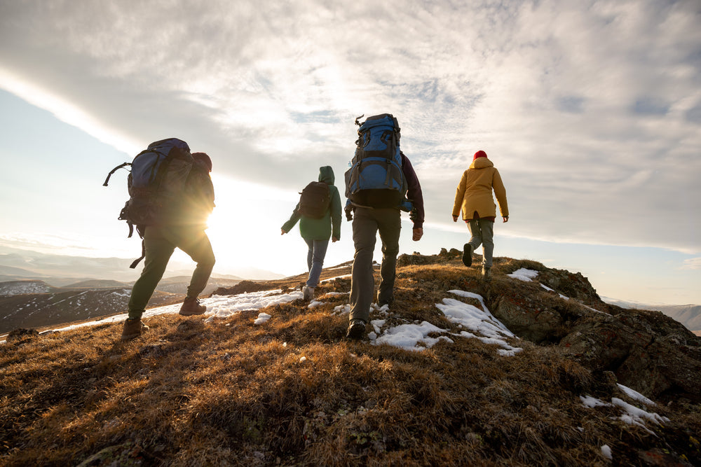 Hikers on a cliff side wearing boots with traction studs in them